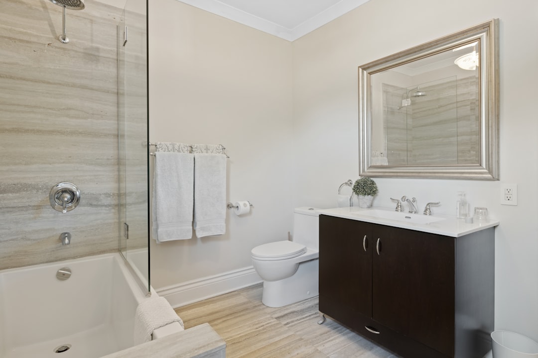a bathroom with a sink, toilet, mirror and bathtub,