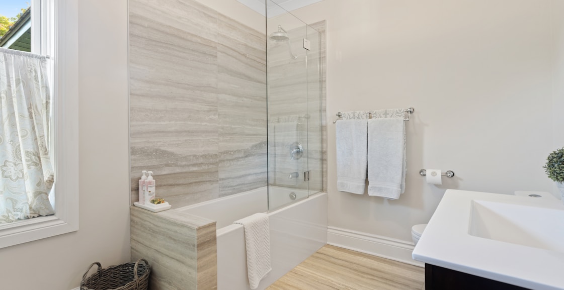 a bathroom with a tub, sink, and mirror