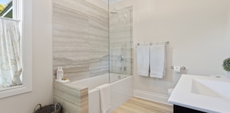 a bathroom with a tub, sink, and mirror