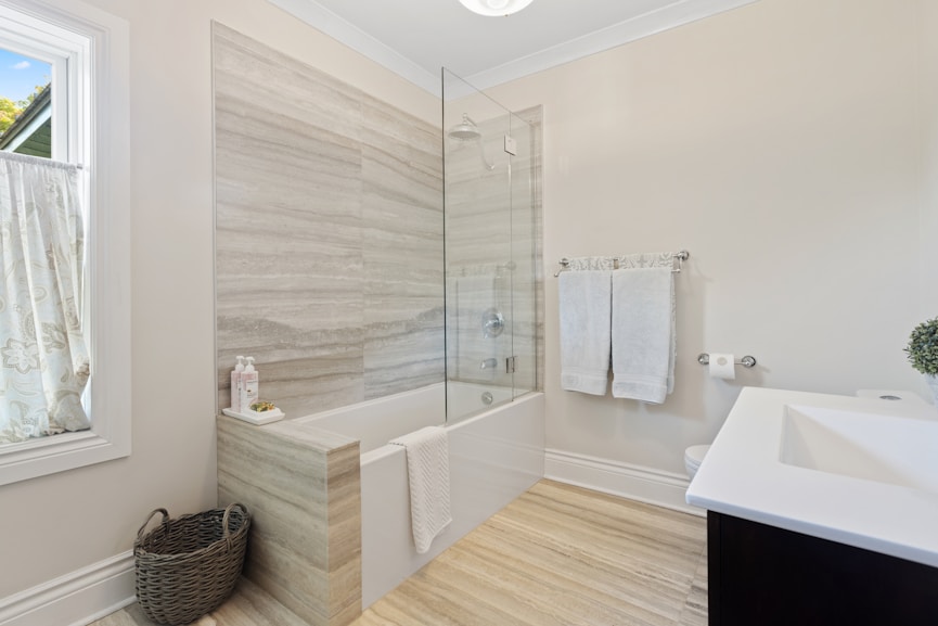 a bathroom with a tub, sink, and mirror