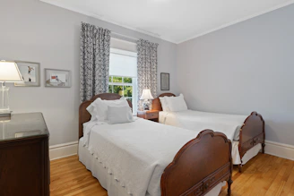 a bedroom with two beds and a desk