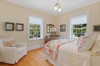 a bed room with a neatly made bed and a chair