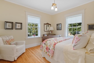 a bed room with a neatly made bed and a chair