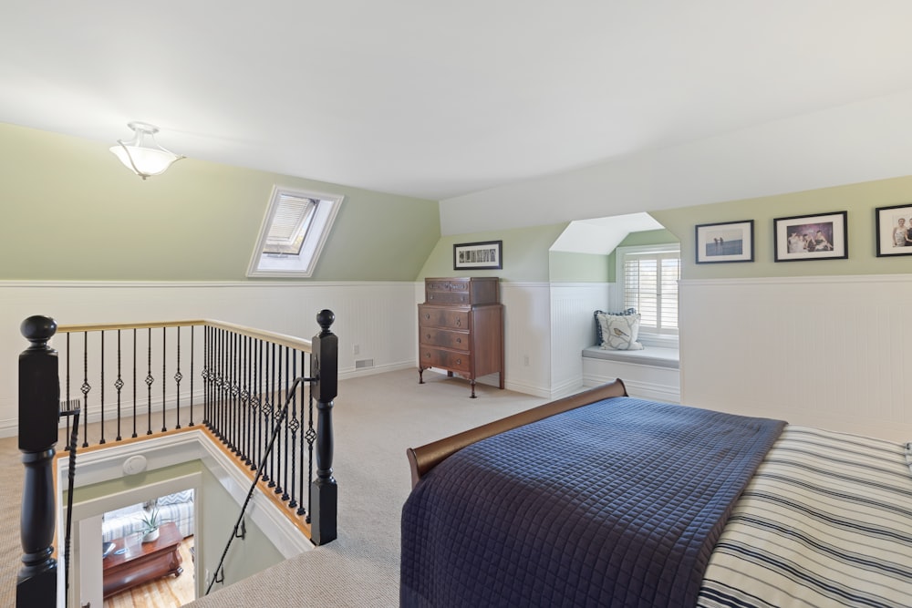 a bedroom with a bed, a dresser, and a balcony