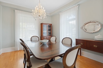 a dining room table with chairs and a china cabinet