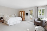 An elegant bedroom featuring a spacious wardrobe and soft lighting.