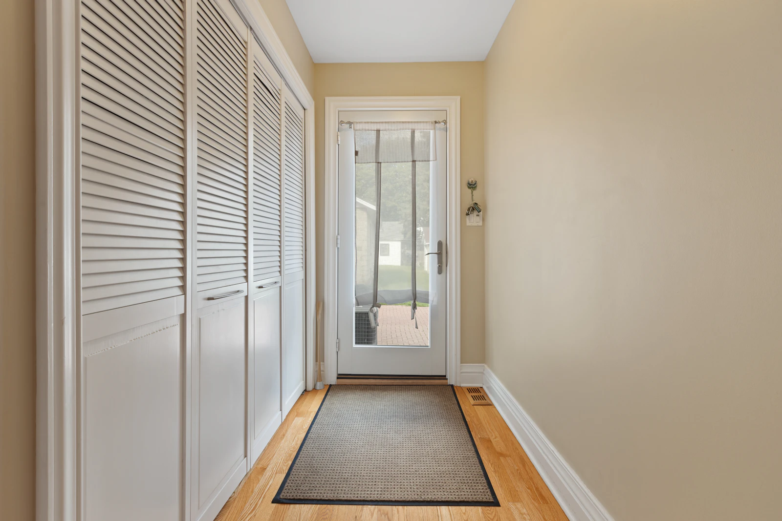 A hallway with a rug on the floor near a door