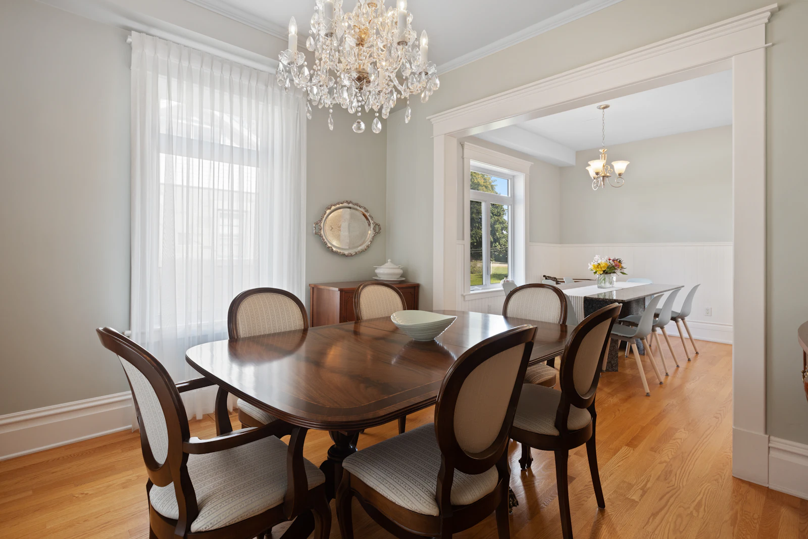 A dining table with chairs and a chandelier above it