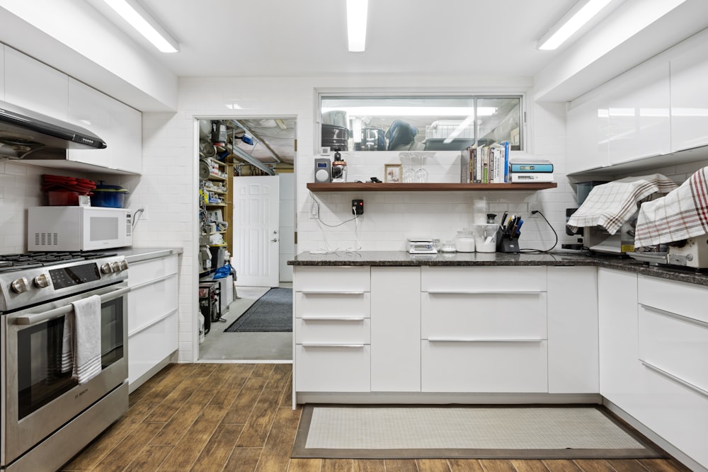 a kitchen with white cabinets and stainless steel appliances