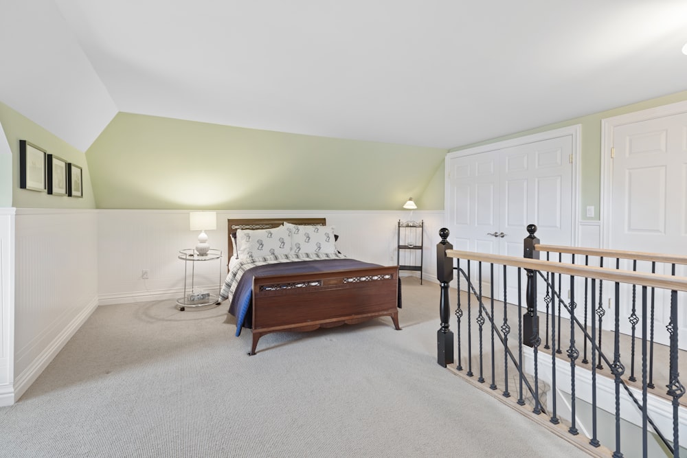 a bedroom with a bed, dresser, and stairs