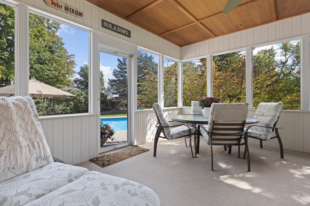 a covered patio with a table and chairs