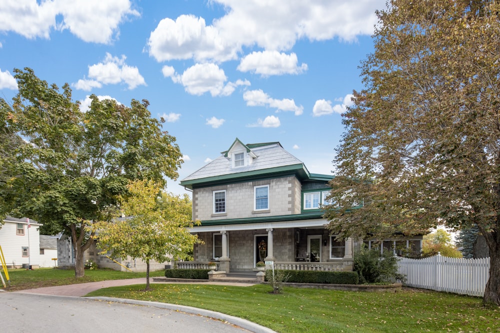 a house with a green roof and a white picket fence