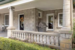 a front porch with columns and a grill