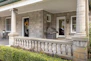 a front porch with columns and a grill
