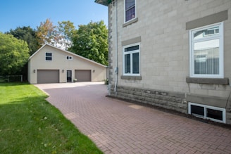 a brick driveway leading to a two story house
