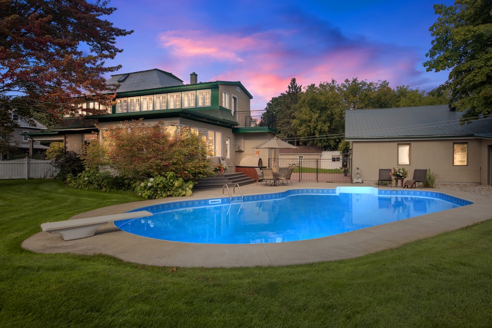 a backyard with a pool and a house in the background