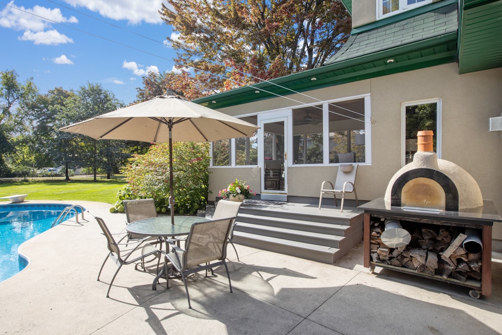 a patio with a table and chairs next to a swimming pool