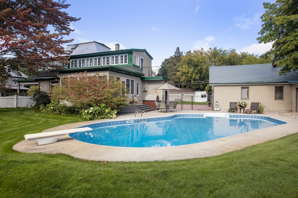 um quintal com uma piscina e uma casa ao fundo