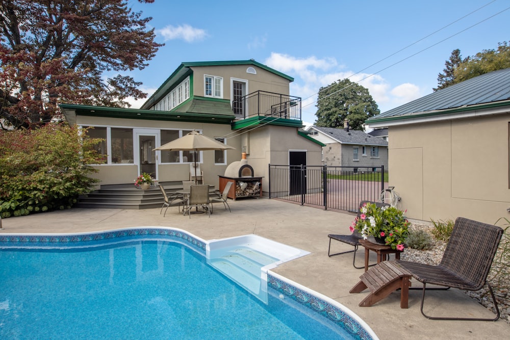 a backyard with a swimming pool and patio furniture