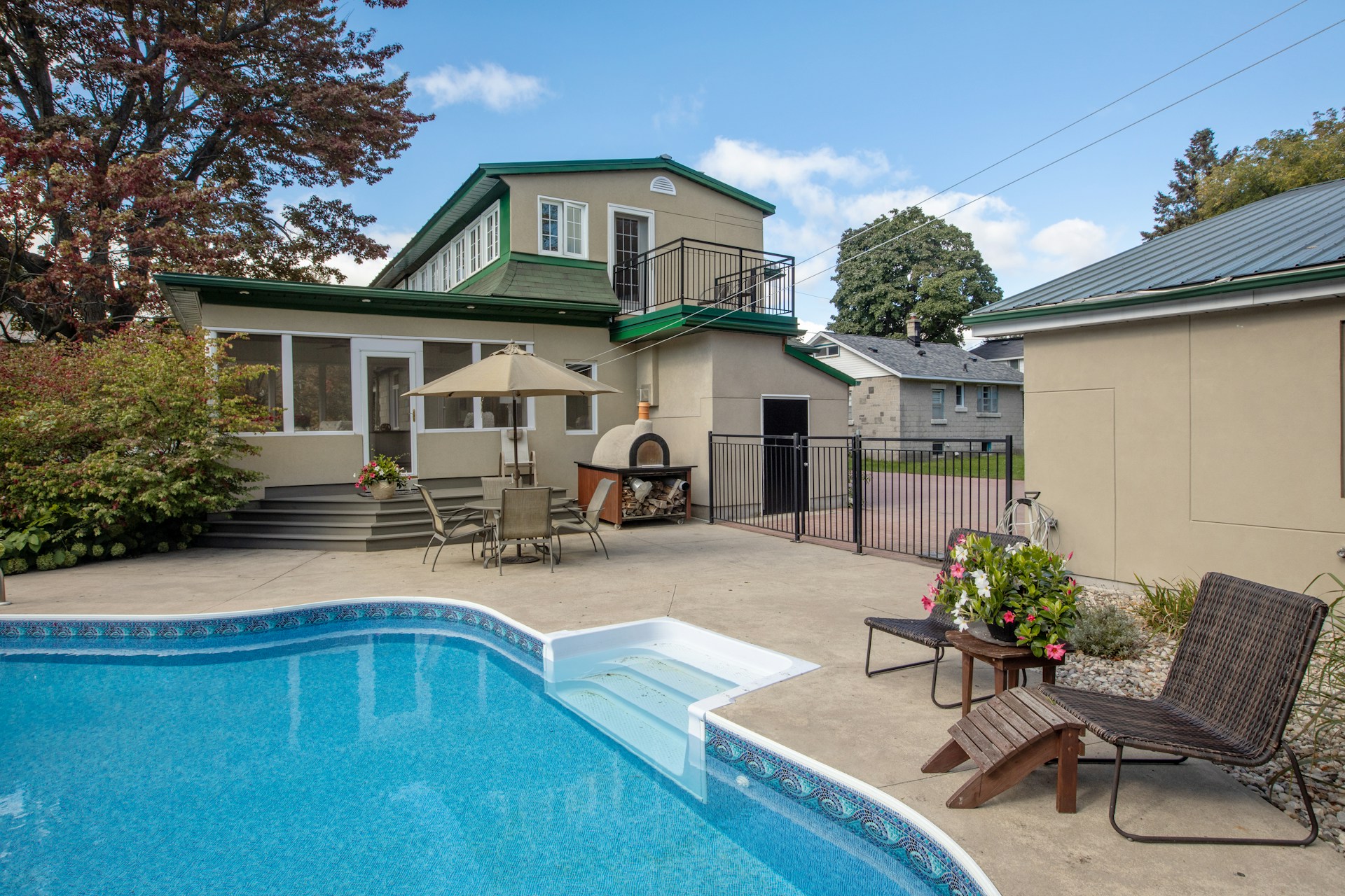 a backyard with a swimming pool and patio furniture