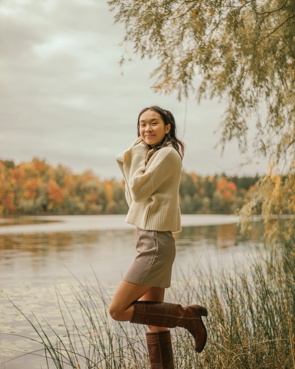 a woman is posing for a picture by the water