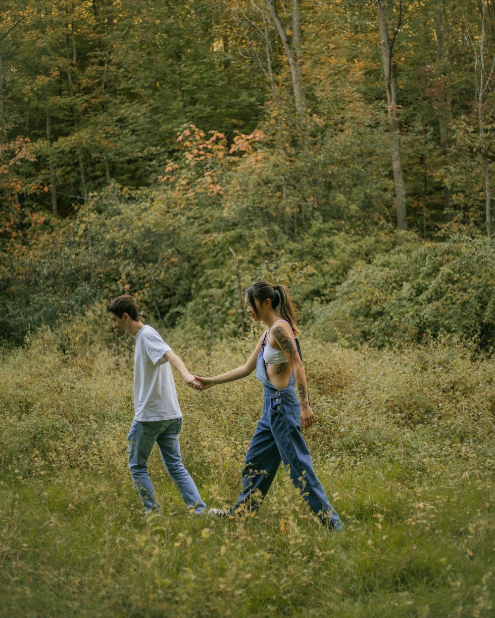 a couple of people holding hands in a field