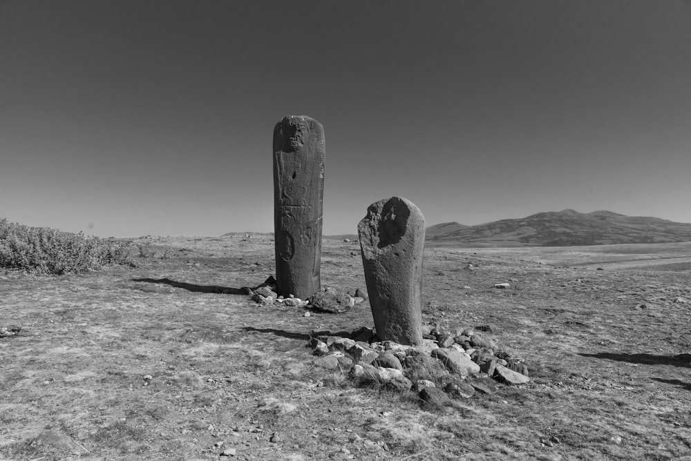 a couple of large rocks sitting in the middle of a field