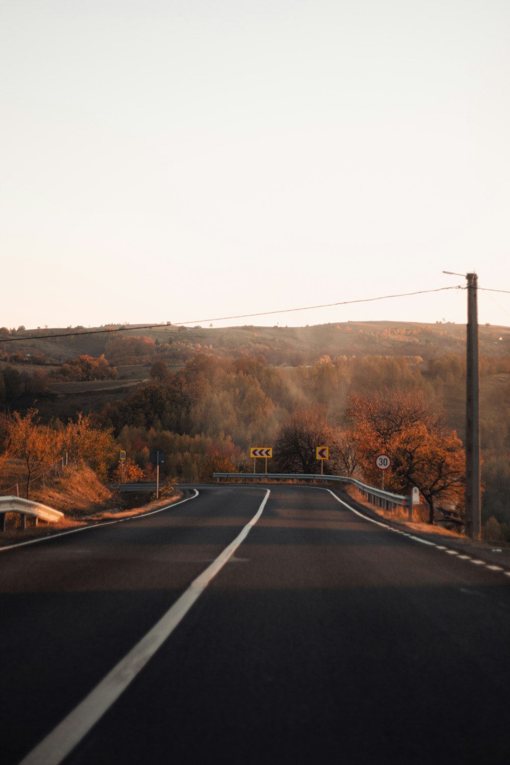 an empty road in the middle of a rural area