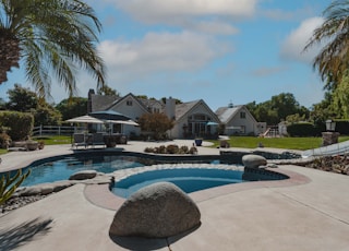 a pool surrounded by palm trees and landscaping