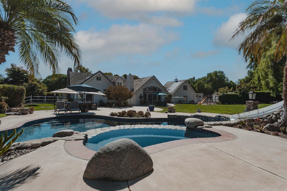 a pool surrounded by palm trees and landscaping