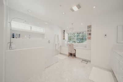a large white bathroom with a tub and sink