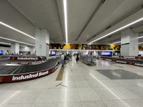A traveler happily receiving their luggage promptly at the airport baggage claim.
