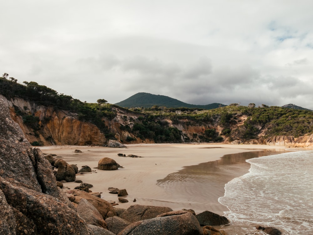 Una playa de arena junto al océano bajo un cielo nublado