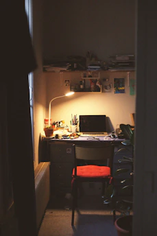 A cozy workspace with a journal, a cup of tea, and soft natural light streaming through a window.