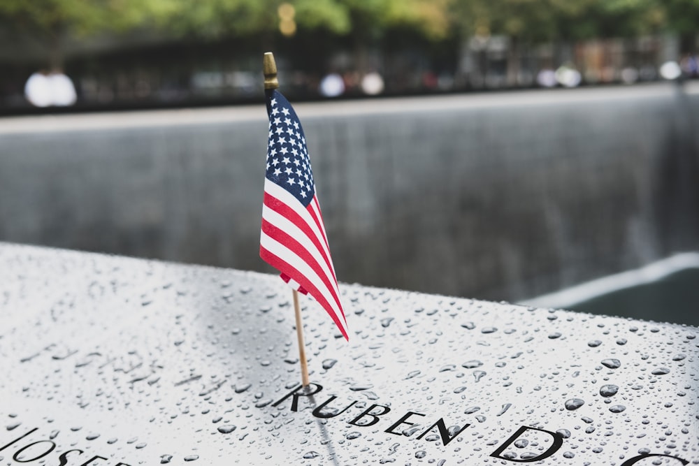 uma pequena bandeira americana é colocada em um memorial