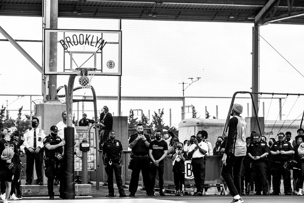 a group of people standing around a basketball court