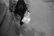 Model wearing a monochrome tracksuit walking confidently on a city street.