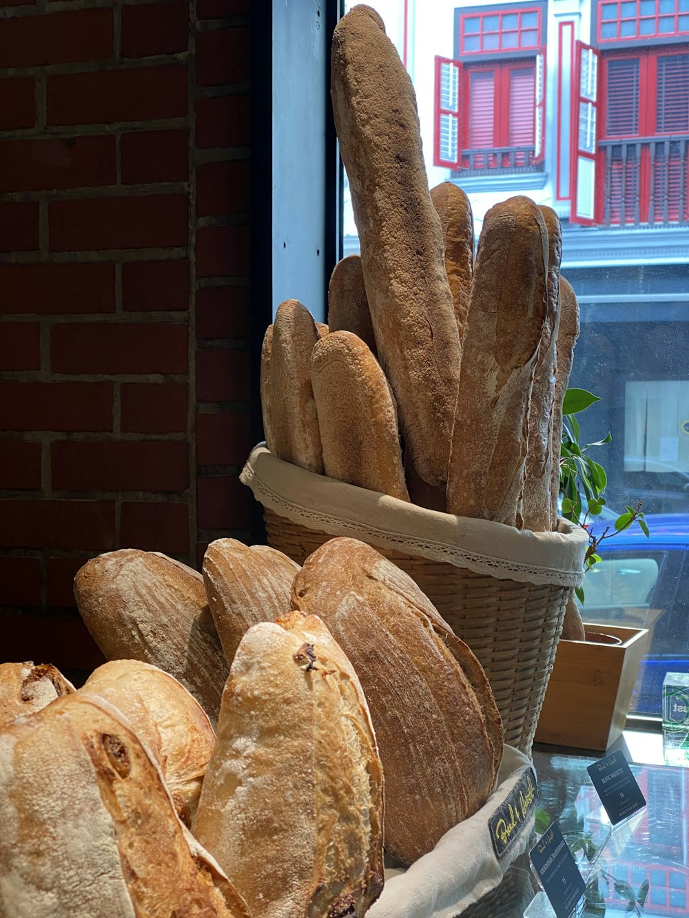 a basket filled with lots of bread next to a window
