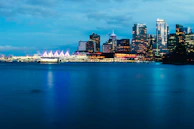 High-resolution photo of the Düsseldorf Medienhafen skyline at dusk with cool blue lighting.