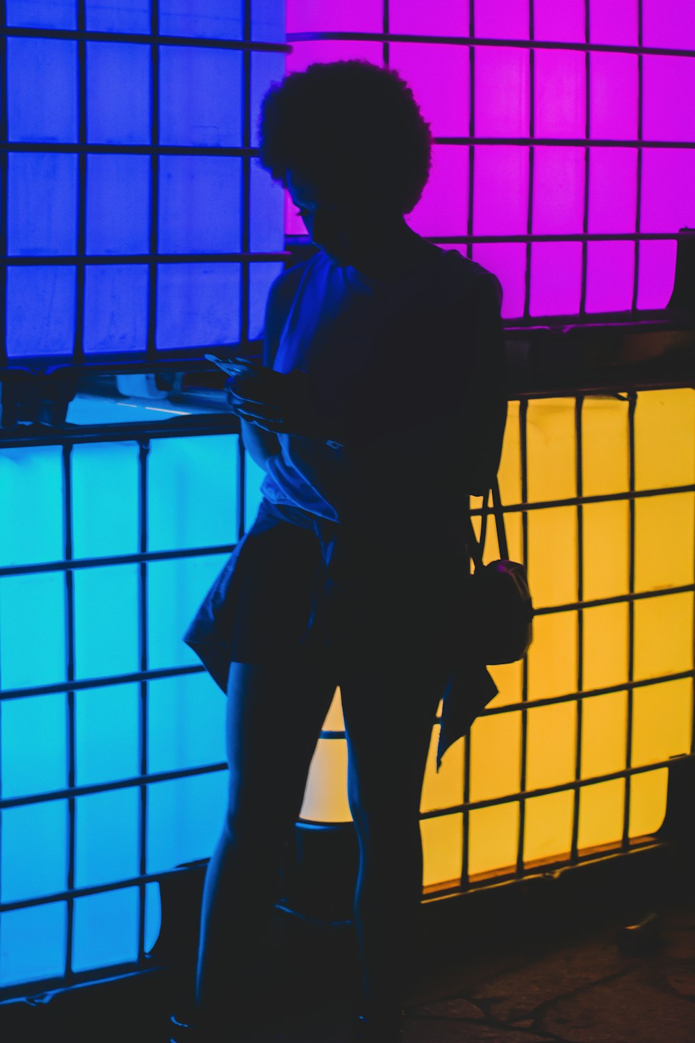 a woman standing in front of a colorful wall