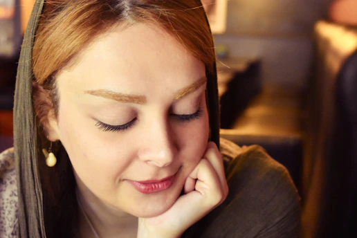 a woman sitting down with her eyes closed