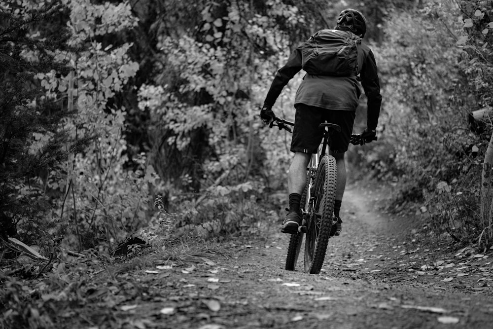 a man riding a bike down a dirt road