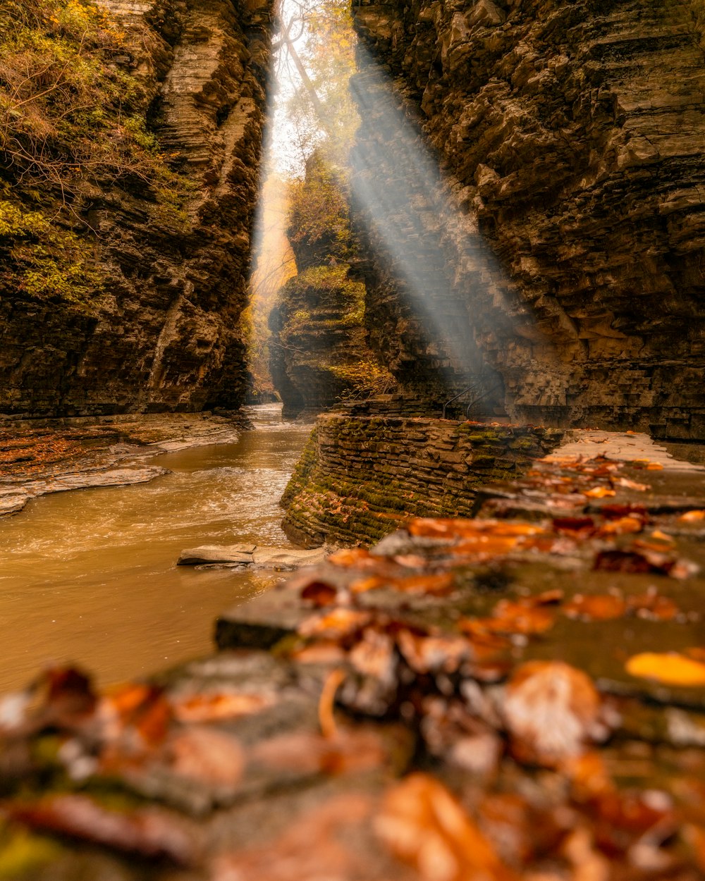 Ein Lichtstrahl scheint in einen Fluss, der von Felsen umgeben ist