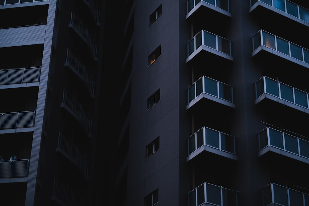 Un edificio alto con balcones y balcones iluminados por la noche