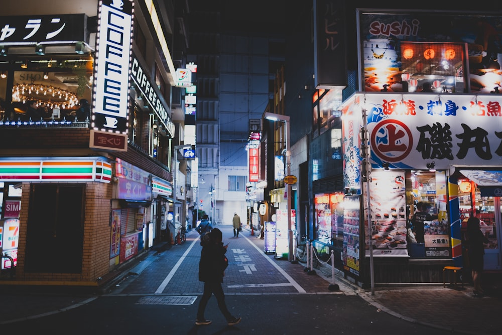 a person walking down a city street at night