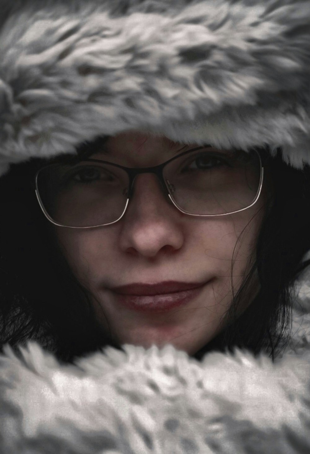 a woman wearing glasses and a fur coat