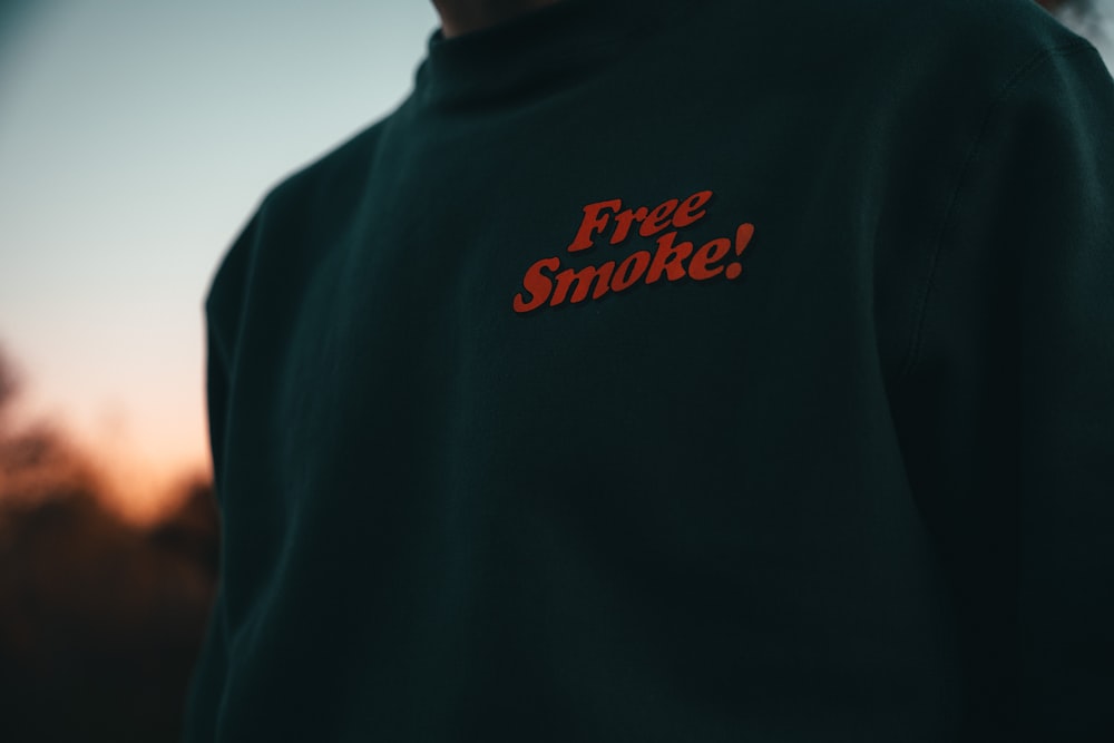 a man wearing a black sweatshirt with a red slogan on it