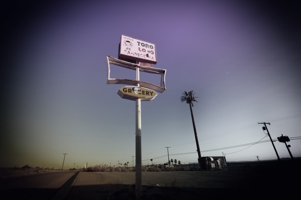 a gas station sign sitting on the side of a road