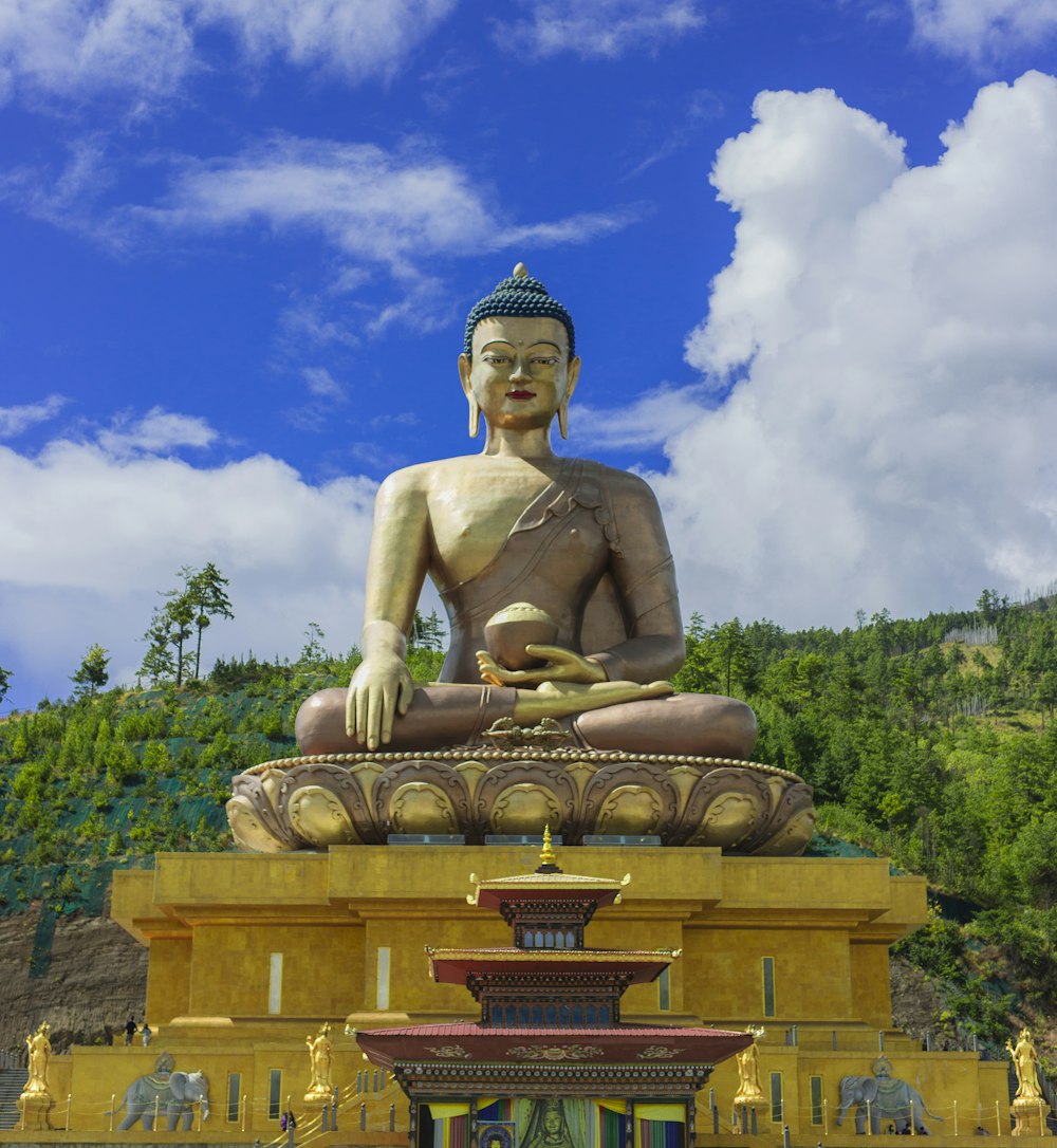 Una grande statua di Buddha seduta sulla cima di una fontana