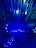 A dynamic and futuristic display featuring numerous elongated blue light beams arranged in a radiating pattern, creating a sense of movement and depth.